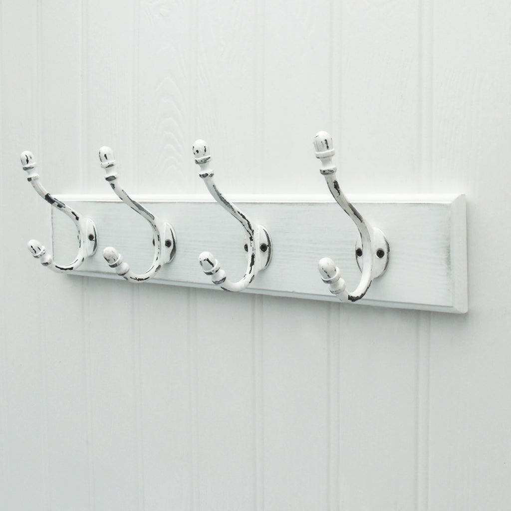 A Shabby Chic White Wooden Coat Hook Rack with Distressed Cast Iron Hooks