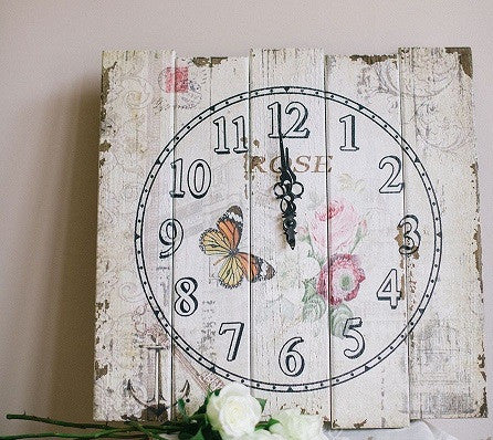A Rustic distressed floral print wooden plank clock .