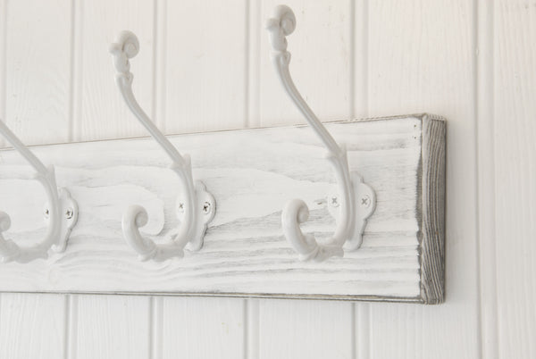 A Distressed White Wooden Coat Rack with 5 Cast Iron Ornate Hooks